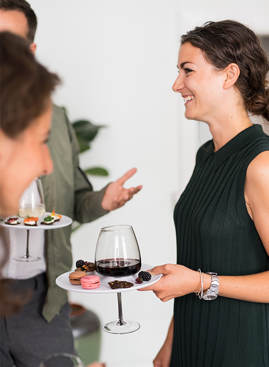 Girl networking and having fun while holding a plate and a glass using just one hand